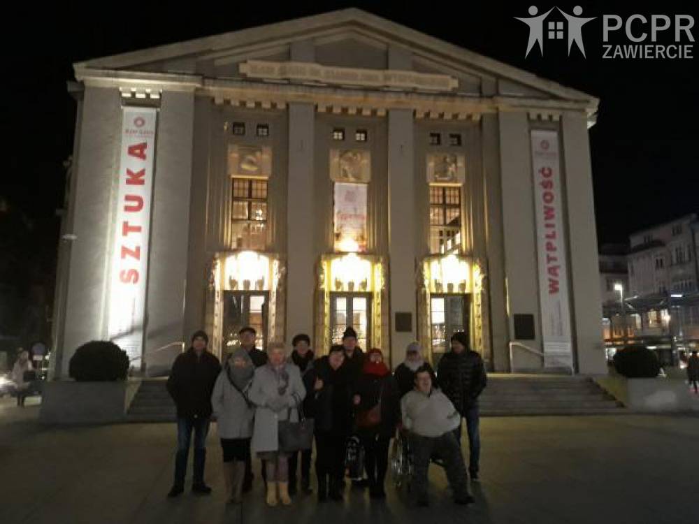 Zdjęcie: Grupa kobiet i mężczyzn stoi przed budynkiem Teatru im. S. Wyspiańskiego w Katowicach